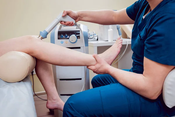 Shock wave therapy. The magnetic field, rehabilitation. Physiotherapist doctor performs surgery on a patient's knee — Stock Image Shock Wave Therapy Magnetic Field Rehabilitation Physiotherapist Doctor Performs Surgery Stock Picture