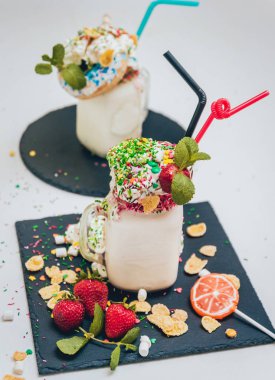 İle sprinkles, çilekli milkshake bardak çırpılmış krema ve taze çilek