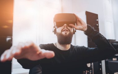 Sanal gerçeklik giyen sakallı genç adam ofiste gözlükler