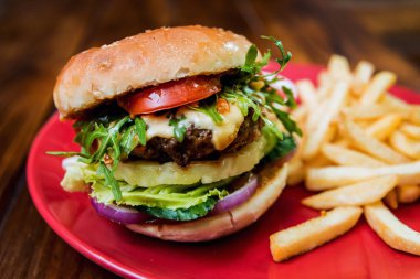 Büyük çizburger ve patates kızartması bir plaka üzerinde. Restoran