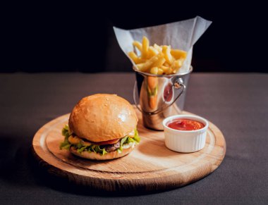 Yangınlar ahşap tahta üzerinde büyük ve lezzetli burger.