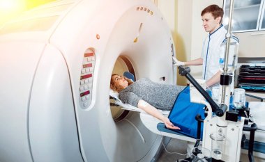 Tıbbi malzeme. Erkek beyaz doktor ve Bayan hasta hastanede bilgisayarlı tomografi odası.