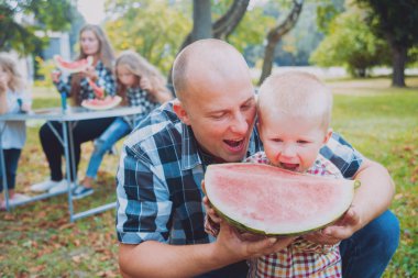 Büyük genç aile parkta iyi vakit geçiriyor.