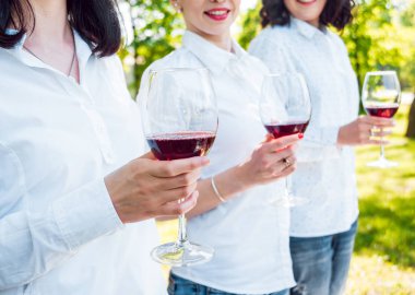 Parkta kırmızı şarap gözlüklü genç güzel kız.