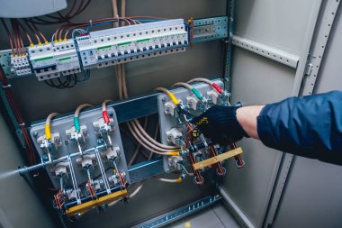 Elektrik kutusuna anahtarları test elektrikçiler eller. Sigortalar ve Kontaktörler elektrik paneli.