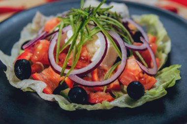 Lahana, zeytin ve mozzarella peyniri siyah plaka üzerinde Yunan salatası