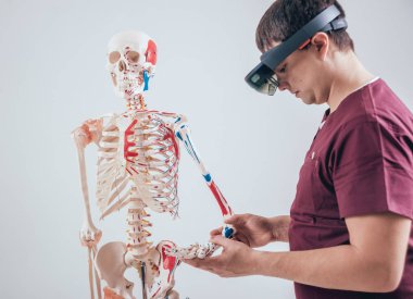 Doktor insan iskeletini incelemek için artırılmış gerçeklik gözlüğü kullanıyor.