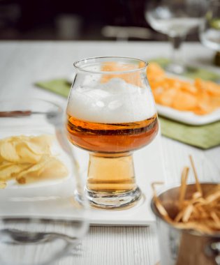 Bira ve büyük beyaz masanın üzerindeki fişlere. Restoran