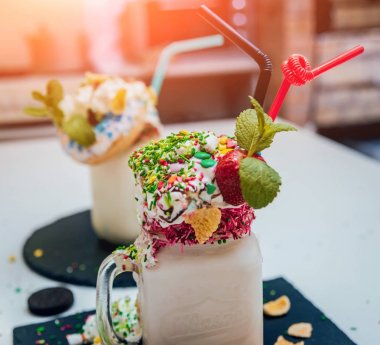 Sprinkles ile çilekli milkshake bardak çırpılmış krema ve taze çilek