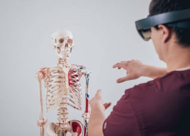Doktor insan iskeletini incelemek için artırılmış gerçeklik gözlüğü kullanıyor.