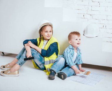 Örgüler ve onarım veya inşaat oynayan erkek kardeşi ile küçük kız