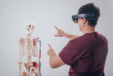 Doktor insan iskeletini incelemek için artırılmış gerçeklik gözlüğü kullanıyor.