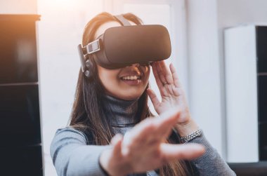 Sanal gerçeklik giyen genç ve güzel kız ofiste gözlükler