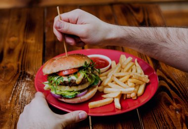 Kırmızı plaka üzerinde yangınları ile büyük ve lezzetli burger.