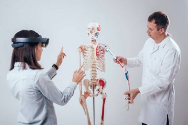 Doktor kullanır augmented gerçeklik gözlükleri ve öğrenci öğretim insan iskeleti