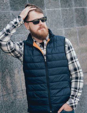 Yakışıklı adam açık havada kameraya poz rahat kıyafetler içinde sakallı