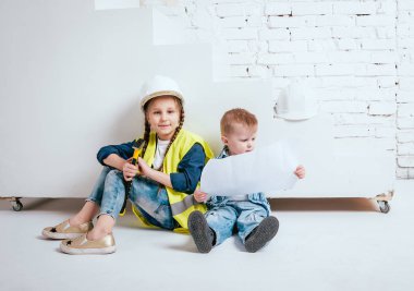 Örgüler ve onarım veya inşaat oynayan erkek kardeşi ile küçük kız