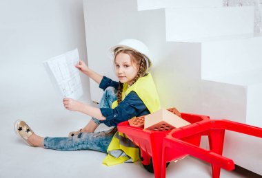 Onarım veya inşaat oynarken örgüler ile küçük neşeli kız