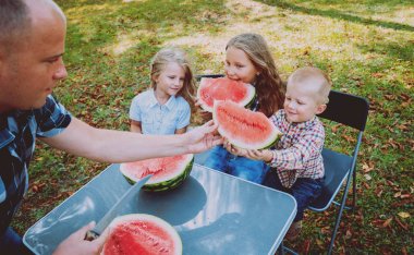 Yeşil Yaz parkta karpuz yeme çocuklu büyük aile