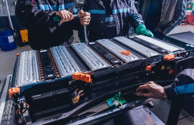 Elecric motorlu pilleri şarj. Pil bir elektrikli araç motorunun sökülmesi. Araba Servisi