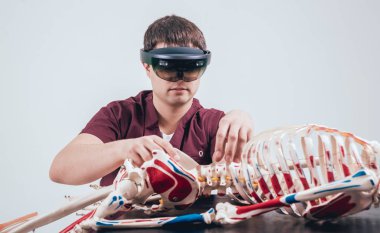 Doktor insan iskeletini incelemek için artırılmış gerçeklik gözlüğü kullanıyor.