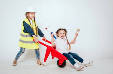 Onarım veya inşaat beyaz üzerinde oynarken örgüler ile iki küçük neşeli kız