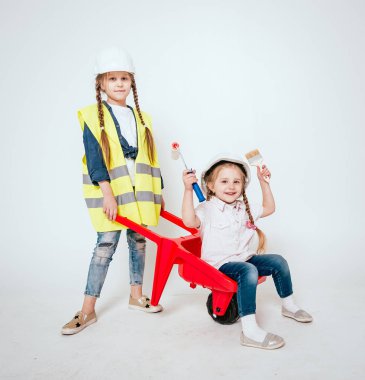 Onarım veya inşaat beyaz üzerinde oynarken örgüler ile iki küçük neşeli kız