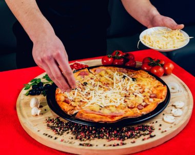 Aşçı pizza yapıyor. Malzemeler ekler. Bir restoran