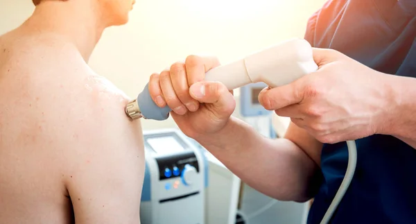 Şok dalga tedavisi. Manyetik alan, rehabilitasyon. Fizyoterapist doktor cerrahi hastalarda omuz üzerinde gerçekleştirir.