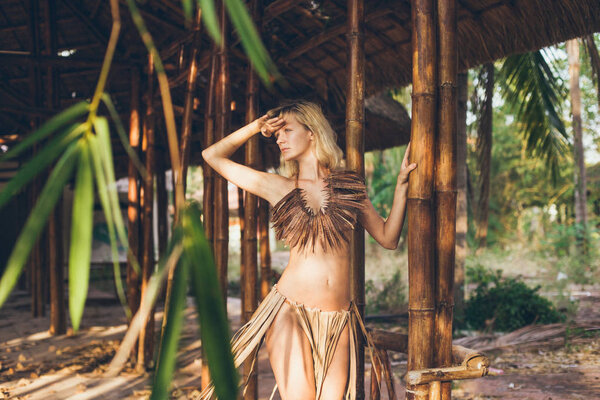 Красивая амазонка позирует перед бамбуком
 