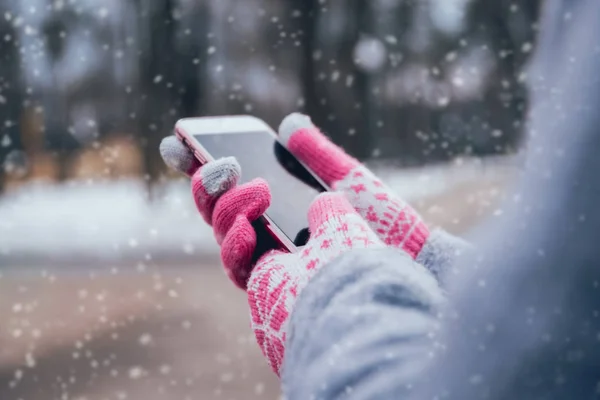 妇女使用智能手机与粉红色手套在冬季触摸屏 — 图库照片
