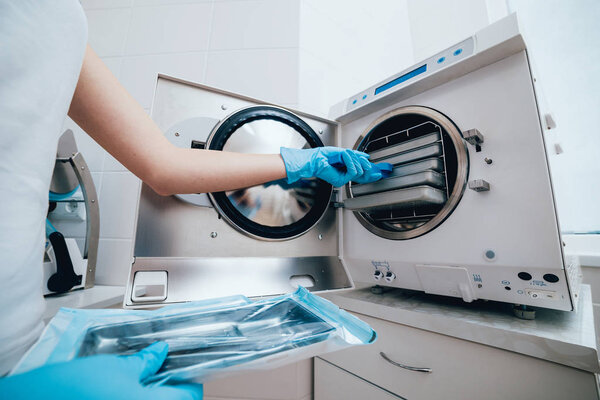 Sterilizing medical instruments in autoclave. Dental office.