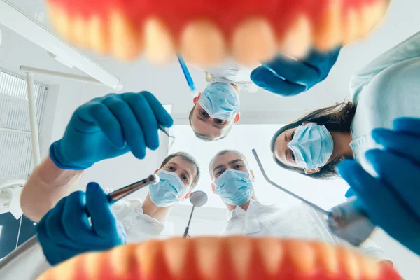 Quattro Dentisti Uniforme Eseguono Operazioni Impianto Dentale Paziente Presso Uno — Foto Stock