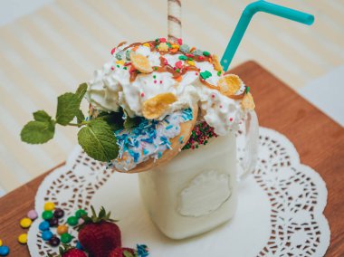 İle sprinkles, çilekli milkshake bardak çırpılmış krema ve taze çilek