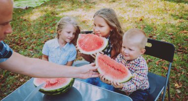 Yeşil Yaz parkta karpuz yeme çocuklu büyük aile