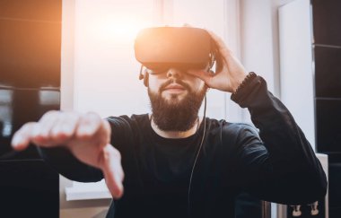 Sanal gerçeklik giyen sakallı genç adam ofiste gözlükler