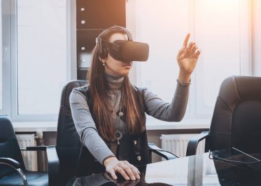 Sanal gerçeklik giyen genç ve güzel kız ofiste gözlükler