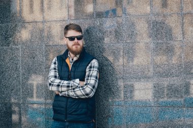 Yakışıklı adam açık havada kameraya poz rahat kıyafetler içinde sakallı