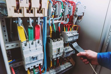 Elektrik donatımı. Elinde Tester.