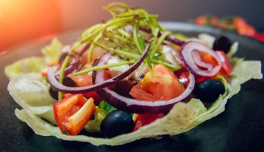 Lahana, zeytin ve mozzarella peyniri siyah plaka üzerinde Yunan salatası