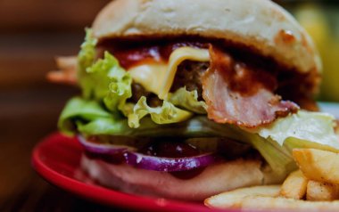 Büyük çizburger ve patates kızartması bir plaka üzerinde. Restoran