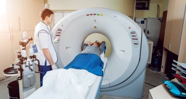 Tıbbi malzeme. Erkek beyaz doktor ve Bayan hasta hastanede bilgisayarlı tomografi odası.