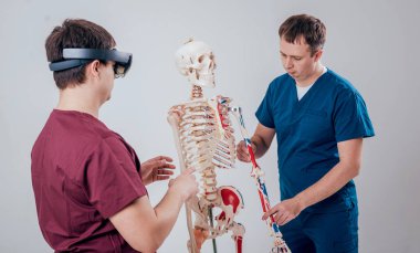 Doktor kullanır augmented gerçeklik gözlükleri ve öğrenci öğretim insan iskeleti