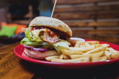 Büyük çizburger ve patates kızartması bir plaka üzerinde. Restoran
