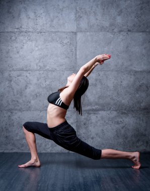 Gri duvar Yoga pratik kadın.