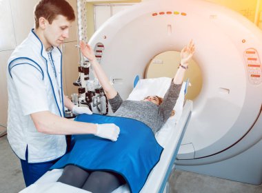 Tıbbi malzeme. Erkek beyaz doktor ve Bayan hasta hastanede bilgisayarlı tomografi odası.