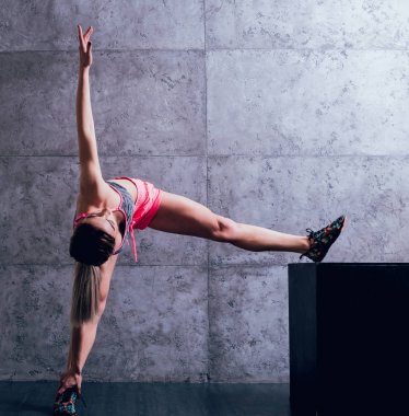 Studio poz ve farklı egzersizleri yapıyor genç atletik beyaz kadın.