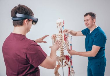 Doktor kullanır augmented gerçeklik gözlükleri ve öğrenci öğretim insan iskeleti