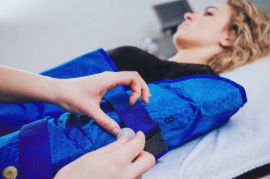 Genç kadın spa salonda. Pressotherapy Güzellik Merkezi kadında makinede. Kozmetik tıp cihazları
