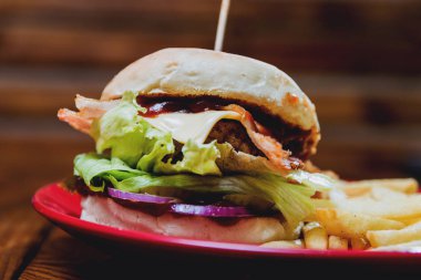 Büyük çizburger ve patates kızartması bir plaka üzerinde. Restoran